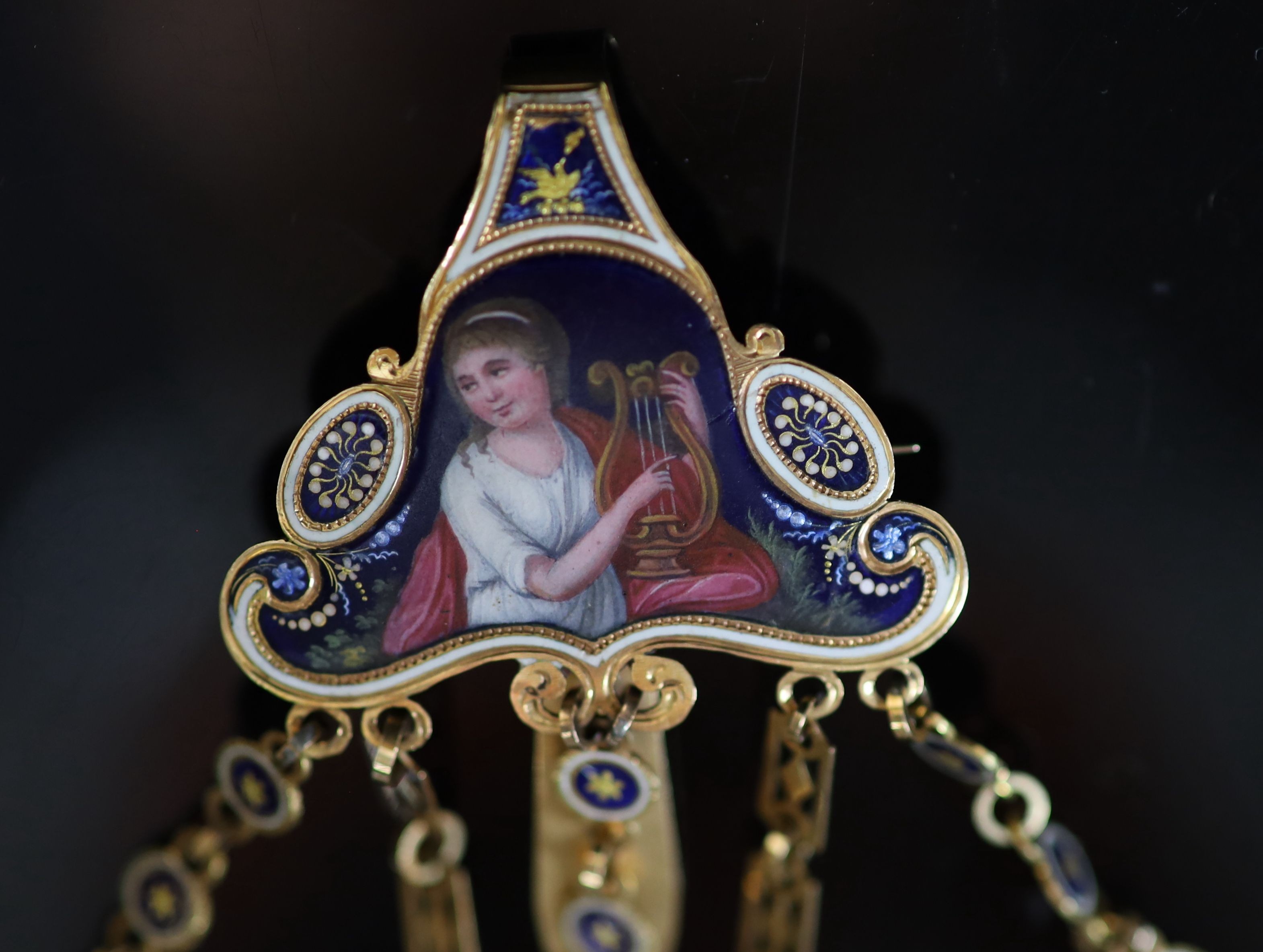 An early 19th century French or Swiss gold and enamel chatelaine, hung with eleven assorted accoutrements